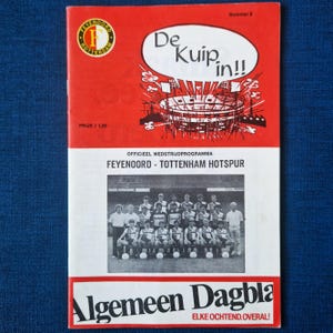 May include: A vintage sports program with a red and white cover. The cover features the text "De Kuip in!!" and a stadium illustration. The program includes a team photo and the text "FEYENOORD - TOTTENHAM HOTSPUR".