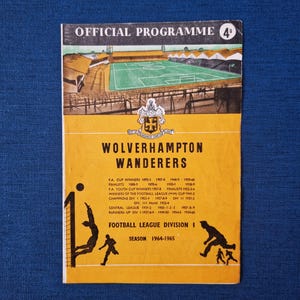 May include: A yellow and black programme for the 1964-1965 season of the Football League Division I. The programme features a crest for Wolverhampton Wanderers, a football pitch, and two footballers. The text "OFFICIAL PROGRAMME 4°" is at the top of the programme. The text "WOLVERHAMPTON WANDERERS" is in large letters below the crest. The text "FOOTBALL LEAGUE DIVISION I" is at the bottom of the programme.