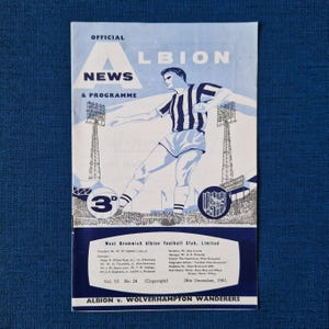 May include: A vintage programme for a West Bromwich Albion football match against Wolverhampton Wanderers. The programme is dated 26th December, 1961, and features a black and white illustration of a player in a striped jersey.
