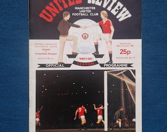 May include: A vintage Manchester United Review program from the 1981-82 season. The cover features the text "UNITED REVIEW" in red and white, with illustrations of players and a football. The program includes details of the Football League Cup match between United and Tottenham Hotspur.