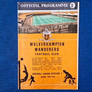 May include: A vintage Wolverhampton Wanderers Football Club programme. The cover is orange and white, with a stadium illustration and the text 'OFFICIAL PROGRAMME'. It lists the team's achievements and the 1959-1960 season.
