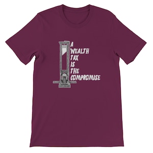 May include: Burgundy short-sleeve t-shirt featuring a guillotine graphic with the text "A Wealth Tax Is The Compromise" in white. The graphic is centered on the front of the shirt. The shirt is made of a soft material.