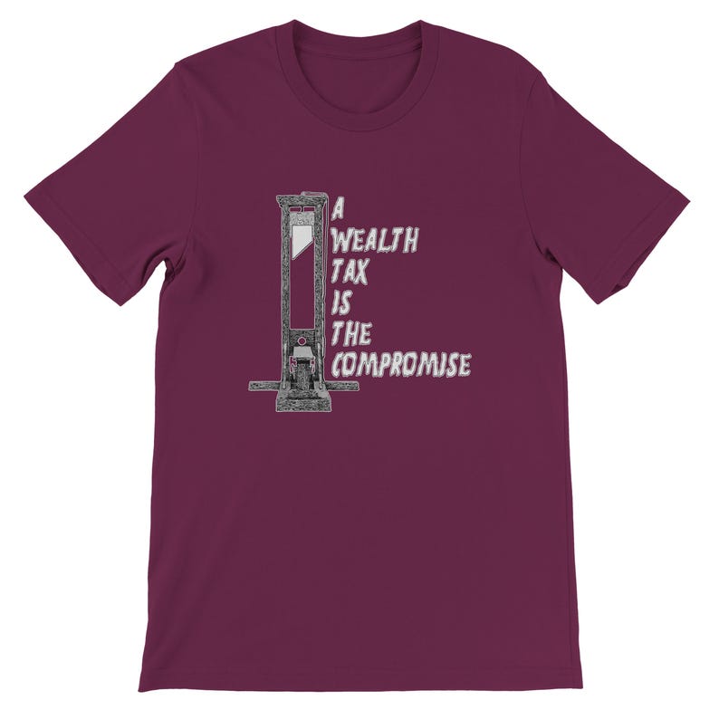 May include: Burgundy short-sleeve t-shirt featuring a guillotine graphic with the text "A Wealth Tax Is The Compromise" in white. The graphic is centered on the front of the shirt. The shirt is made of a soft material.