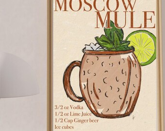 May include: A framed print featuring a Moscow Mule cocktail illustration. The artwork includes a copper mug with ice, mint, and a lime wedge. The text "MOSCOW MULE" is at the top, with the recipe below. A white lamp is in the foreground.