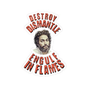 May include: A sticker featuring a man with curly hair and a beard, surrounded by the words "DESTROY DISMANTLE ENGULF IN FLAMES" in red, stylized text. The man has a serious expression.