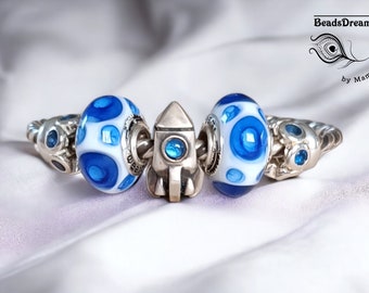 Handcrafted blue crater beads on a white background in spun glass for Pandora type bracelet
