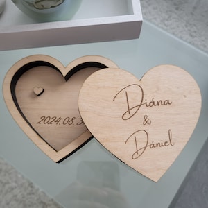 May include: A wooden heart-shaped box with a lid. The lid has the names "Diana & Daniel" engraved on it. The box has the date "2024.08.3" engraved on the inside.