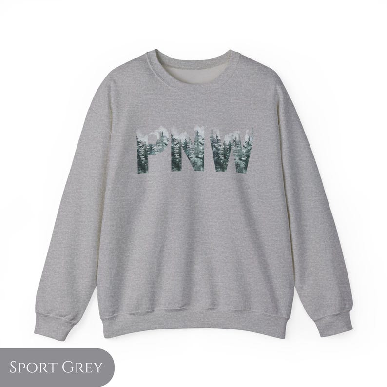 May include: A heather grey sweatshirt with the text "PNW" in a forest green font. The letters are made up of a pattern of evergreen trees.