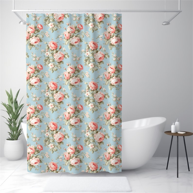 May include: A shower curtain with a floral pattern featuring pink roses on a light blue background.