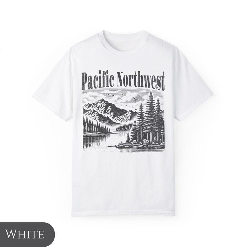Może przedstawiać: Biała koszulka z czarno-białym nadrukiem graficznym przedstawiającym g&oacute;rską scenerię i tekst "Pacific Northwest".