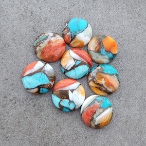 Peut inclure: Une collection de huit cabochons ronds multicolores. Les pierres sont un mélange de turquoise, d'orange, de brun et de blanc. Les cabochons sont lisses et polis.