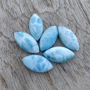 Puede incluir: Seis cabujones ovalados de piedra preciosa azul y blanca con un patrón de mármol.