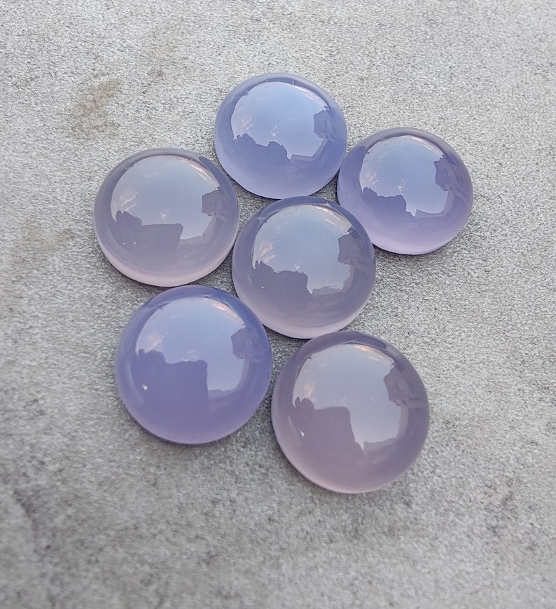 以下が含まれることがあります： 6つの丸い、滑らかな、ラベンダー色のカボションカットの宝石