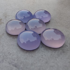 以下が含まれることがあります： 6つの丸い、滑らかな、ラベンダー色の宝石。宝石は半円形に配置されています。