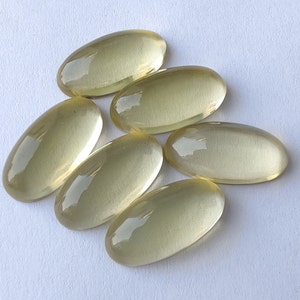 May include: Six oval-shaped, translucent yellow gemstones. The gemstones are smooth and polished.