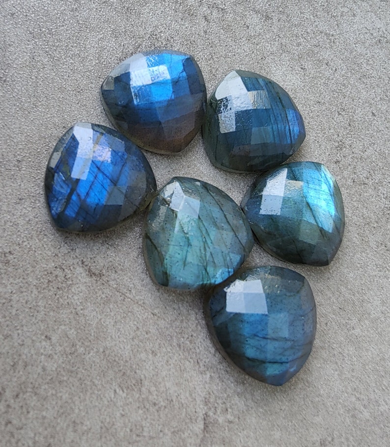 Pu&ograve; includere: Sei cabochon a forma di cuore in labradorite blu iridescente su uno sfondo grigio.