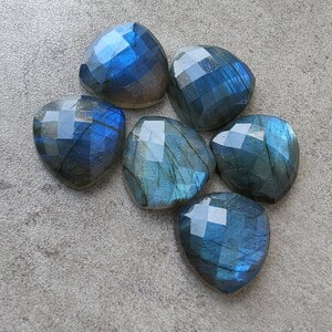Pu&ograve; includere: Sette pietre preziose di labradorite sfaccettate in tonalit&agrave; di blu e verde. Le pietre hanno forma di cuore e hanno una finitura lucida.
