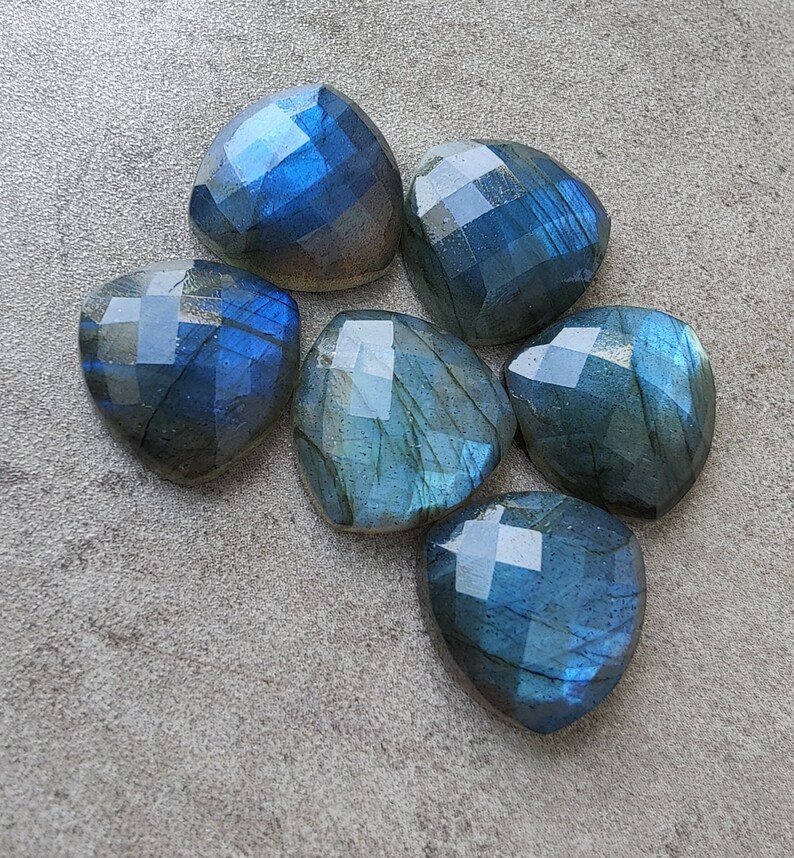 Pu&ograve; includere: Sette pietre preziose di labradorite sfaccettate in tonalit&agrave; di blu e verde. Le pietre hanno forma di cuore e hanno una finitura lucida.