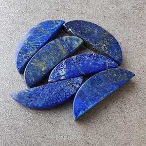 May include: A group of six half-moon shaped lapis lazuli stones. The stones are a deep blue colour with flecks of gold.