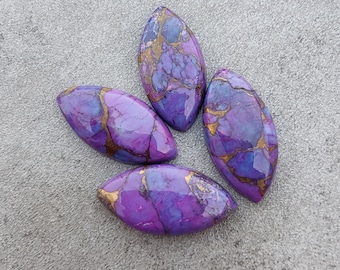 May include: Four purple and gold cabochon stones with a marbled pattern. The stones are oval shaped and have a smooth, polished finish.