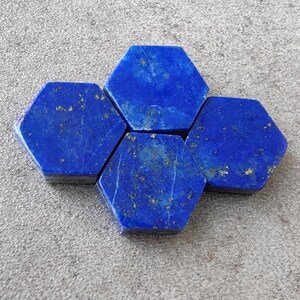 Puede incluir: Cuatro piedras hexagonales de lapislázuli, cada una con un color azul intenso y una textura ligeramente rugosa.