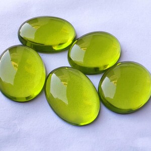 May include: Five smooth, oval-shaped green glass stones. The stones are translucent and have a slight sheen.