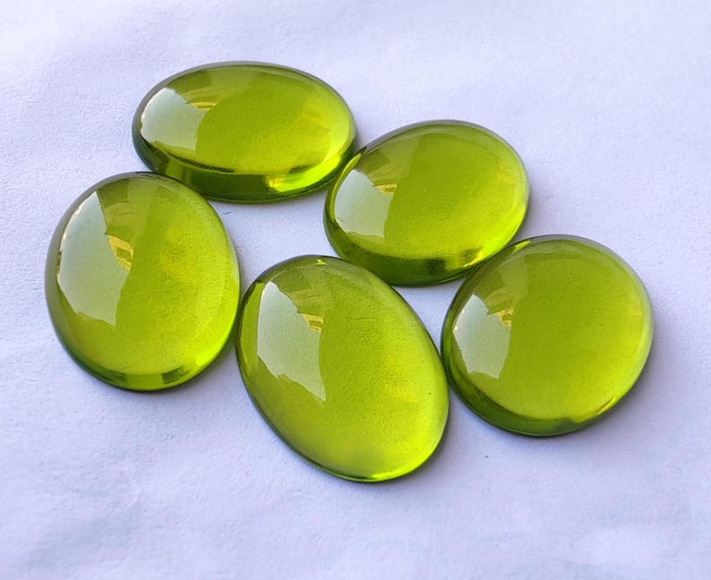 May include: Five smooth, oval-shaped green glass stones. The stones are translucent and have a slight sheen.