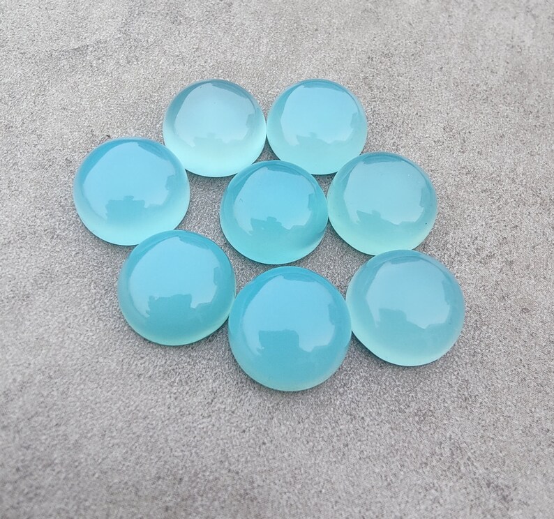 Pu&ograve; includere: Otto cabochon rotondi in pietra preziosa blu chiaro. I cabochon sono lisci e lucidi.