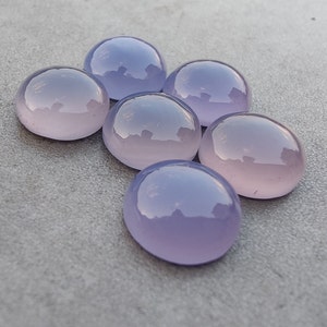 以下が含まれることがあります： 6つの丸い、滑らかな、ラベンダー色の宝石。宝石は半円形に配置されています。