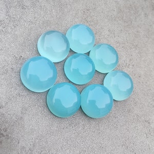 Pu&ograve; includere: Otto pietre preziose rotonde di cabochon blu chiaro. Le pietre preziose sono lisce e lucidate, con un leggero bagliore.