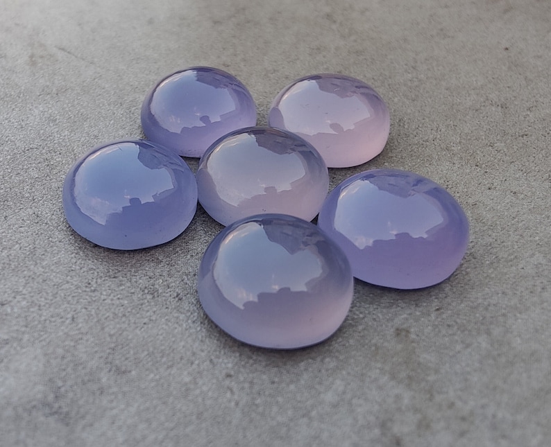 以下が含まれることがあります： ラベンダー色の滑らかで丸い宝石が6つ。石は磨かれており、わずかに光沢があります。