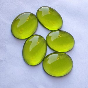 May include: Six oval-shaped, translucent green glass stones. The stones are smooth and polished, with a slight shimmer.