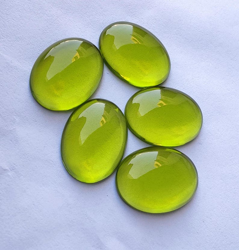 May include: Six oval-shaped, translucent green glass stones. The stones are smooth and polished, with a slight shimmer.