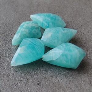 May include: Five teal blue, faceted, teardrop-shaped amazonite gemstones.