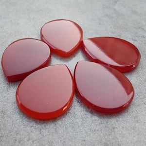 May include: Six teardrop-shaped carnelian stones in shades of red.