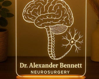 May include: A rectangular LED lamp with a wooden base. The lamp features a white outline of a brain, spinal cord, and neuron. The text "Dr. Alexander Bennett" and "NEUROSURGERY" are displayed in white.