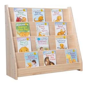 Op de afbeelding: Een houten boekenplank met een verzameling "I Can Read!" boeken met het personage Biscuit. De boeken hebben kleurrijke covers met illustraties van Biscuit in verschillende scenario's. De boekenplank is gemaakt van lichtgekleurd hout.