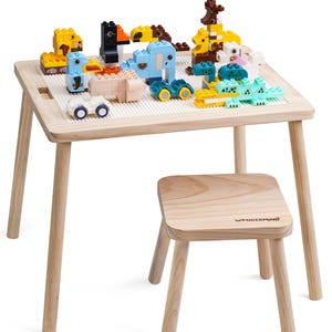 Könnte beinhalten: Ein Holztisch- und Stuhlset für Kinder mit einer weißen, gerasterten Oberfläche zum Bauen mit Blöcken. Der Tisch ist aus Naturholz gefertigt und hat ein schlichtes Design. Der Stuhl ist ebenfalls aus Holz und hat eine kleine, quadratische Sitzfläche. Das Set ist perfekt, um Fantasiespiel und Kreativität zu fördern.