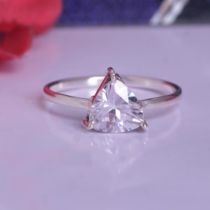 Peut inclure: Une bague en argent avec une pierre triangulaire transparente.