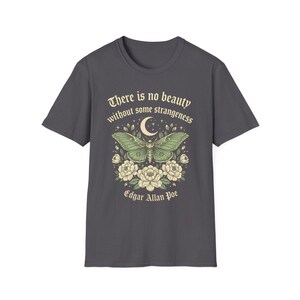 May include: Dark gray t-shirt featuring a green moth design with a crescent moon and floral accents. The text "There is no beauty without some strangeness" and "Edgar Allan Poe" are printed above and below the moth illustration.