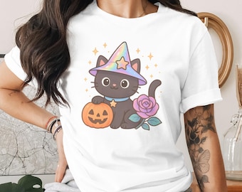 Op de afbeelding: Wit T-shirt met een cartoon zwarte kat met een heksenhoed met een ster, een pompoen vasthoudend en naast een paarse roos. De kat heeft een blauwe halsband met een ster. Halloween-kleding.
