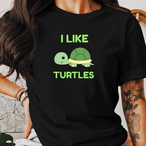 May include: Black t-shirt with a green cartoon turtle and the text "I like turtles" in green.