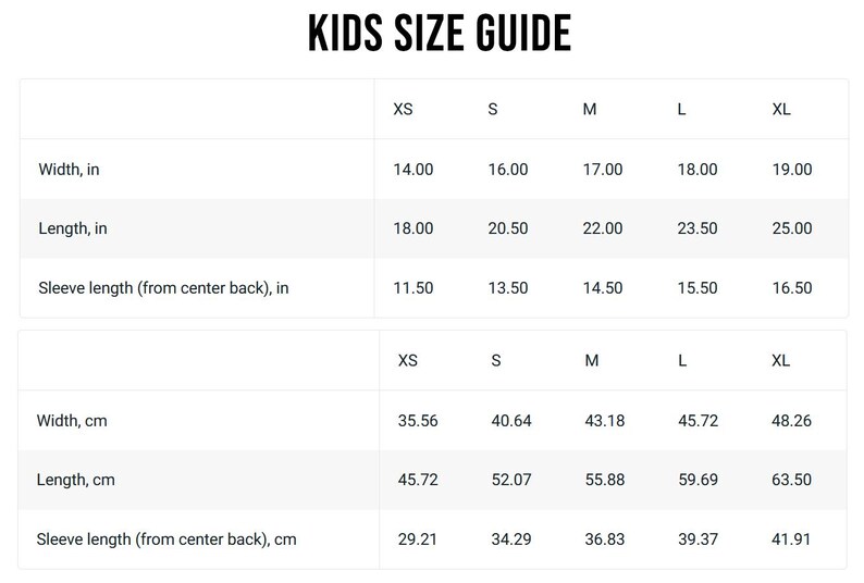 May include: A white chart titled "KIDS SIZE GUIDE" with measurements in inches and centimetres. The chart includes width, length, and sleeve length measurements for sizes XS to XL. Width ranges from 35.56 cm to 48.26 cm.