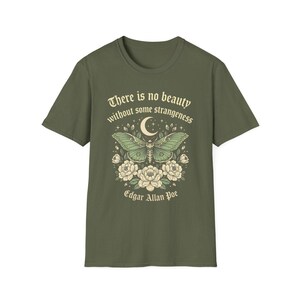 May include: Olive green t-shirt featuring a detailed illustration of a moth with a crescent moon and floral elements. The shirt includes the quote "There is no beauty without some strangeness" and the name "Edgar Allan Poe".