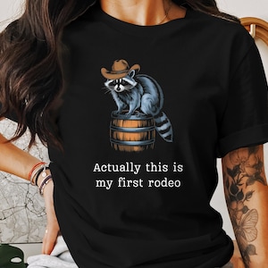 Actually This Is My First Rodeo T-Shirt - Funny Western Graphic Tee Raccoon Quote Shirt Cowboy Shirt