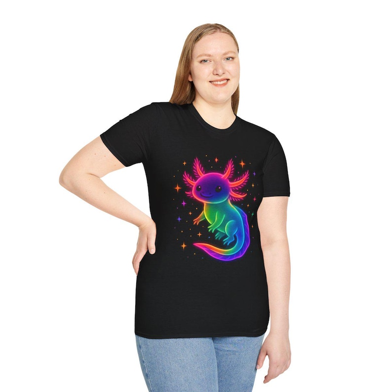 May include: Black t-shirt with a neon-coloured axolotl design. The axolotl is rendered in a gradient of colours, including purple, blue, green, and pink, set against a starry backdrop. The shirt has a classic crew neck.