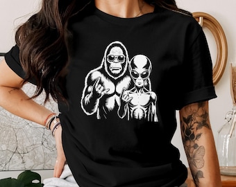 Camiseta de Pie Grande y Alien Rock - Camiseta con gráfico de Críptidos, Señal de Mano Metálica de Pie Grande, Camiseta de Alien con Gafas de Sol Geniales, Regalo Paranormal, Camiseta Rockera