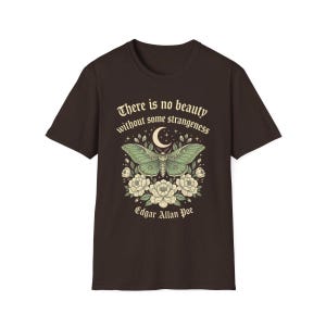 May include: Dark brown t-shirt featuring a green moth design with a crescent moon and floral accents. The shirt includes the quote "There is no beauty without some strangeness" and the name "Edgar Allan Poe".
