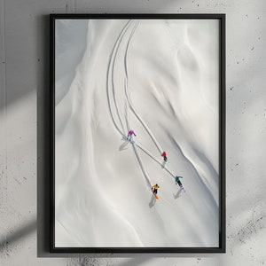以下が含まれることがあります： 雪山を滑るスキーヤーを上から見たフレーム入りプリント。カラフルな衣装を着たスキーヤーが白い雪に跡を残しています。黒いフレームが鮮やかなコントラストを生み出し、視覚的に魅力的なアート作品となっています。
