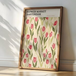 Rustic kitchen decor featuring a framed Amsterdam pastel floral exhibition poster on a wooden counter with copper pots.